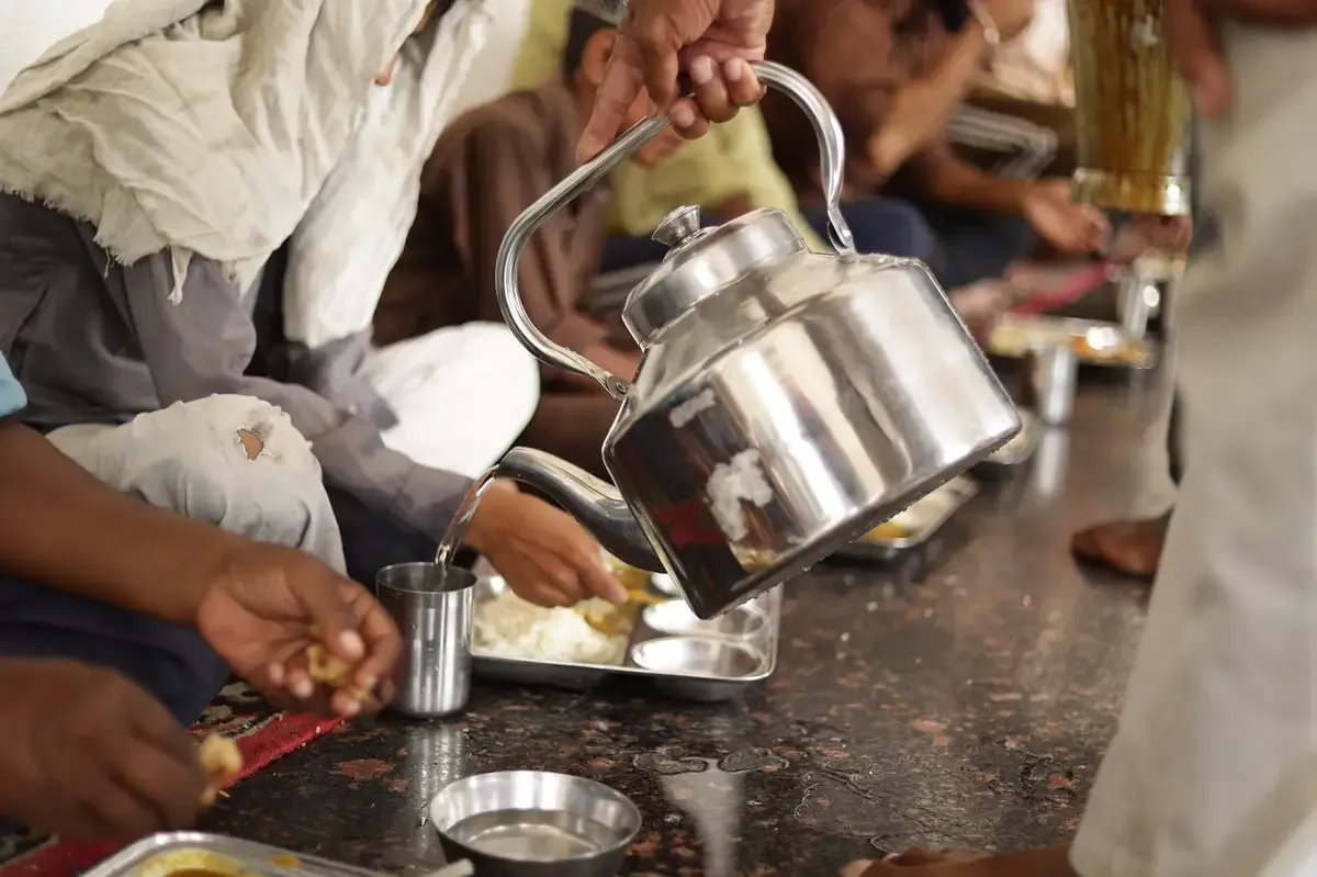 A sewadar serving water during Langar